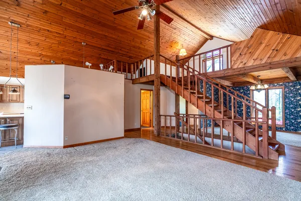 a living room with furniture large windows and wooden floor