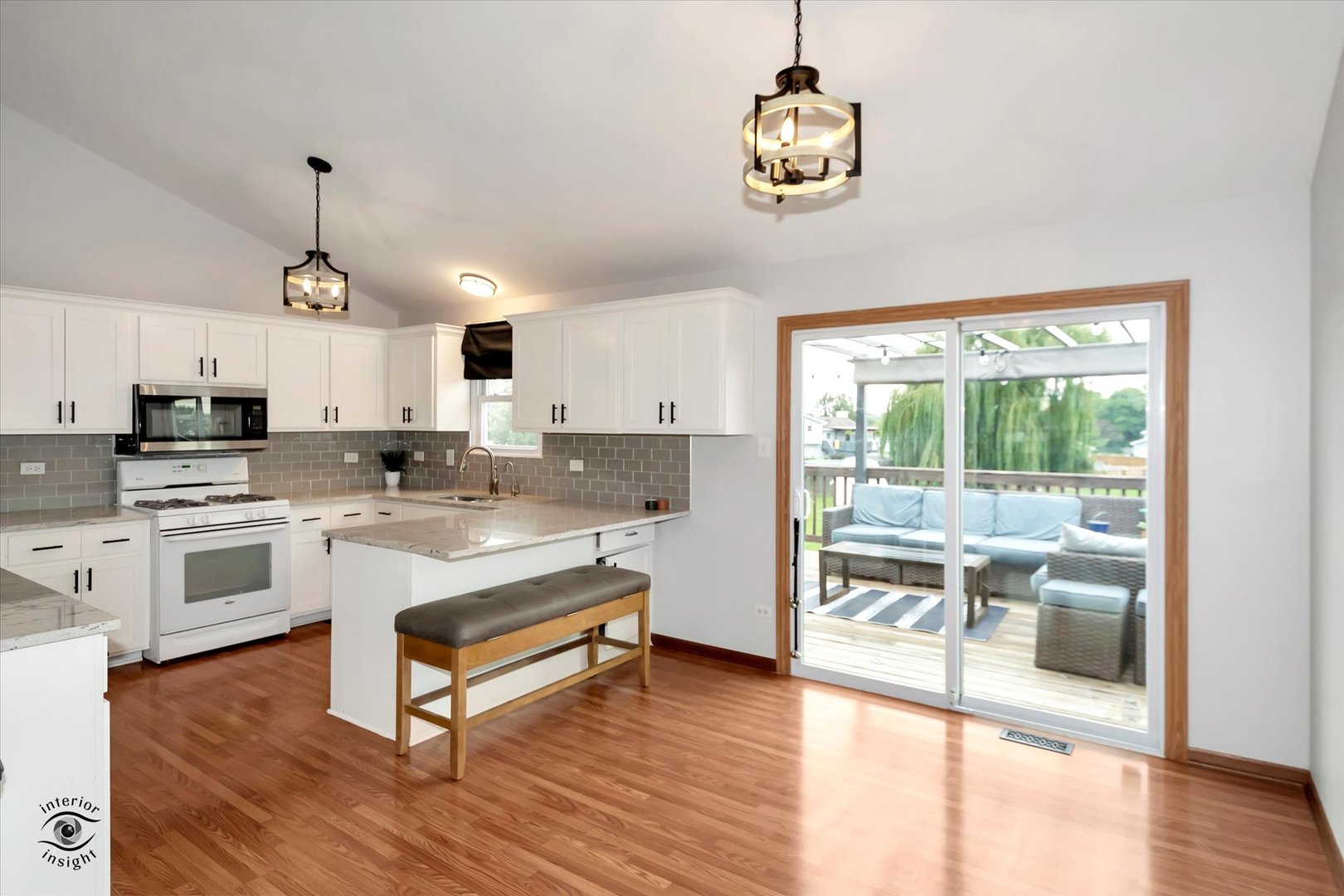 7507 West Tartan Road Frankfort, IL 60423 - Photo 5 of 25 a open kitchen with granite countertop a stove and white cabinets with wooden floor
