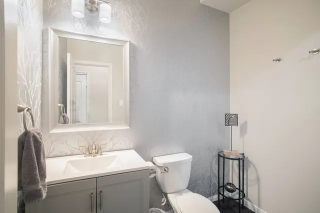 a bathroom with a toilet a sink and mirror