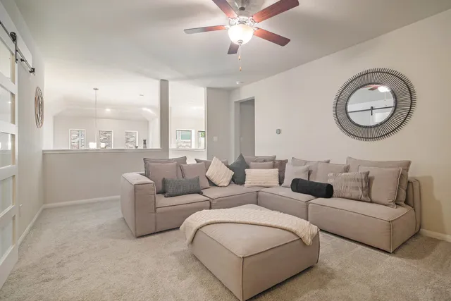 a living room with furniture a large window and a chandelier