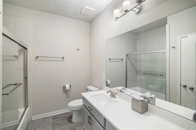 a bathroom with a sink a toilet and shower