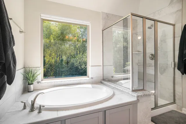 a bathroom with a granite countertop bathtub and a shower