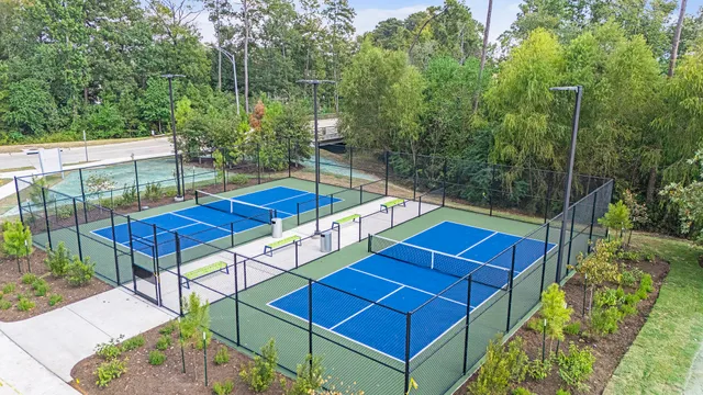a blue swimming pool with lawn chairs and wooden fence