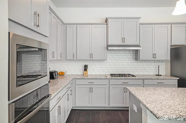 a kitchen with granite countertop white cabinets and white appliances