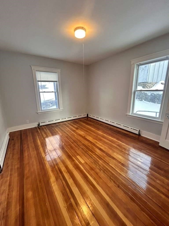 99 Cross Street Southbridge, MA 01550 - Photo 11 of 20 an empty room with wooden floor and windows