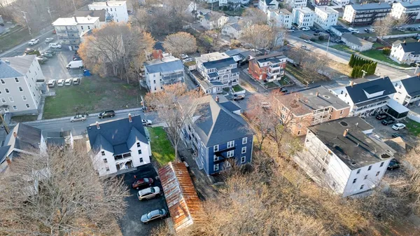 an aerial view of a house with a yard and parking spaces
