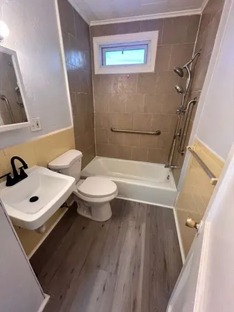 a bathroom with a sink a toilet a mirror and shower