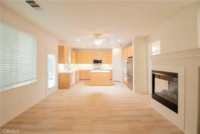 a large kitchen with a refrigerator a stove top oven a sink and dishwasher with wooden floor