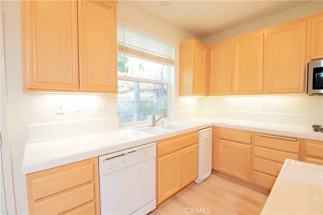 a kitchen with granite countertop white cabinets and a microwave