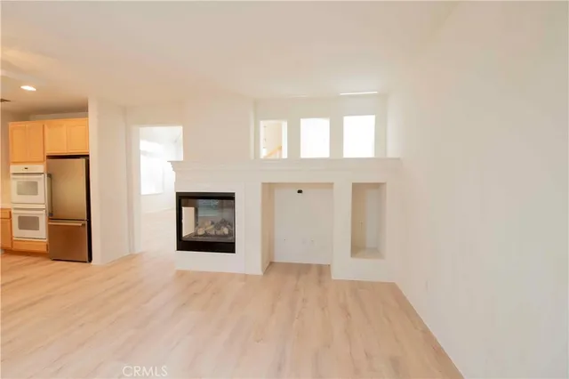 a view of an empty room with window and fire place