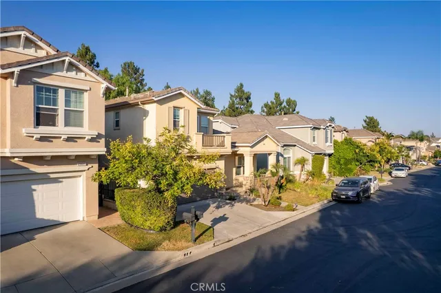 a view of a white house with wooden walls and potted plants