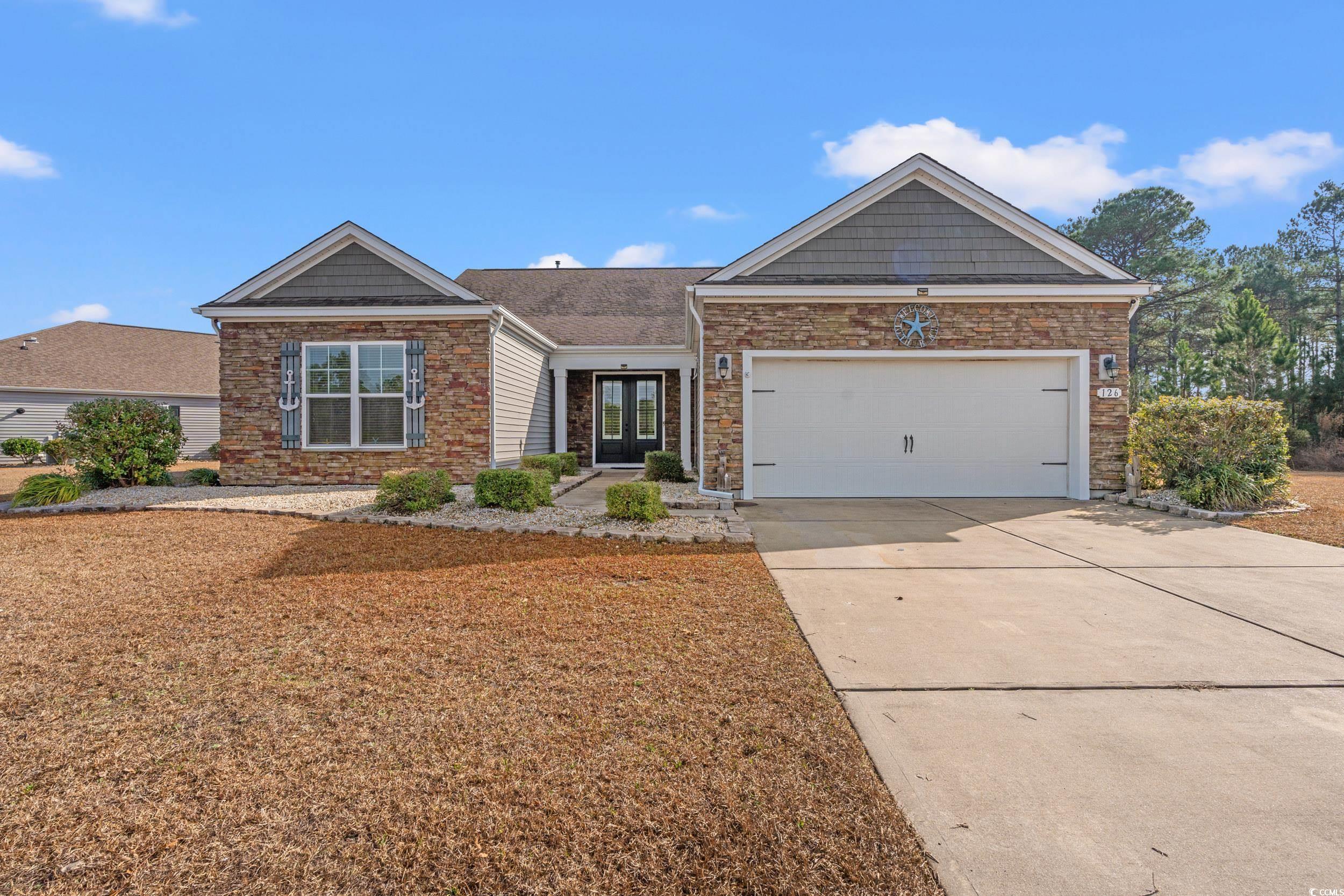 Ranch-style house featuring concrete driveway, stone siding, and a garage