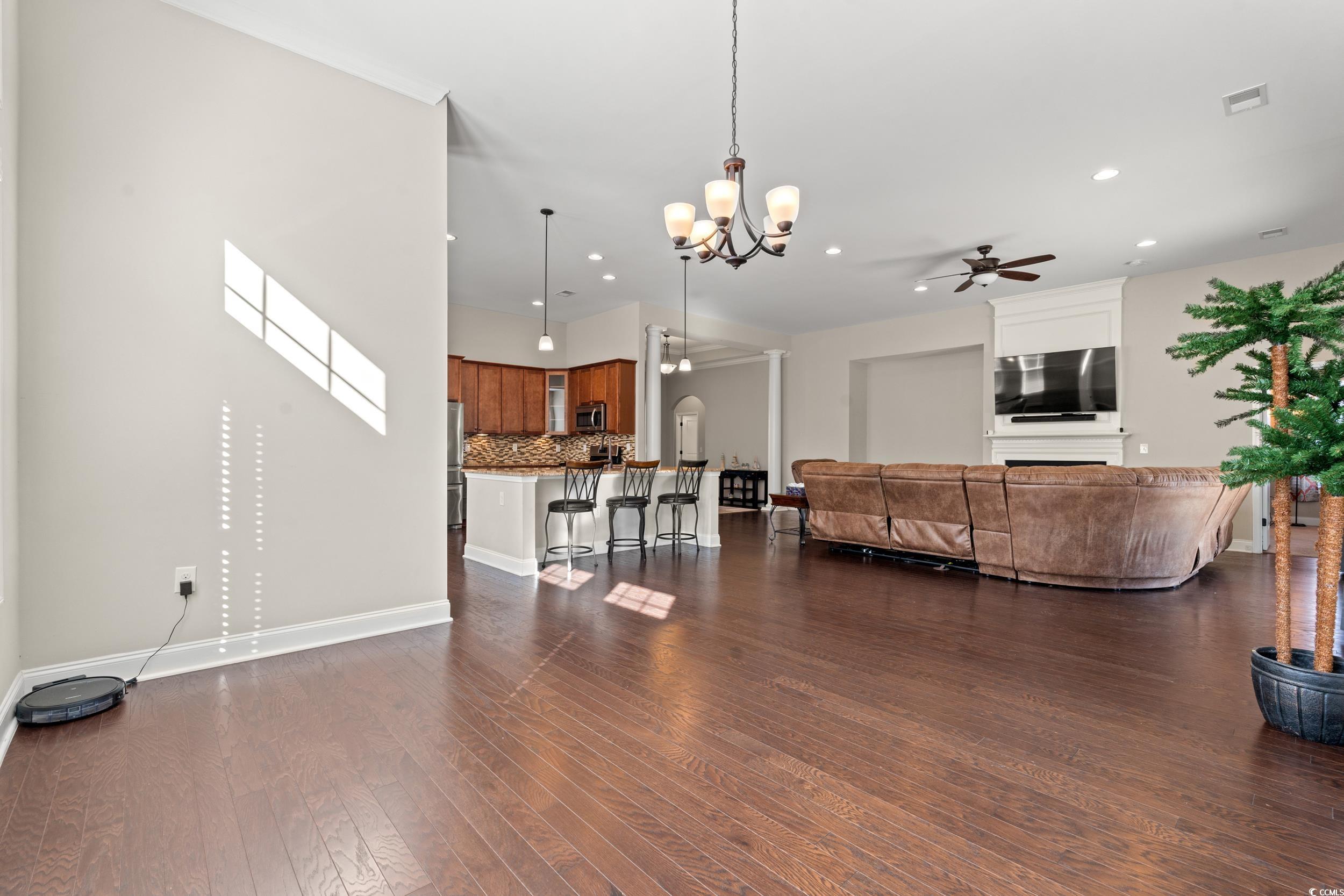 126 Viareggio Road Myrtle Beach, SC 29579 - Photo 11 of 40 Living room with a chandelier, a ceiling fan, dark wood-style flooring, recessed lighting, and arched walkways