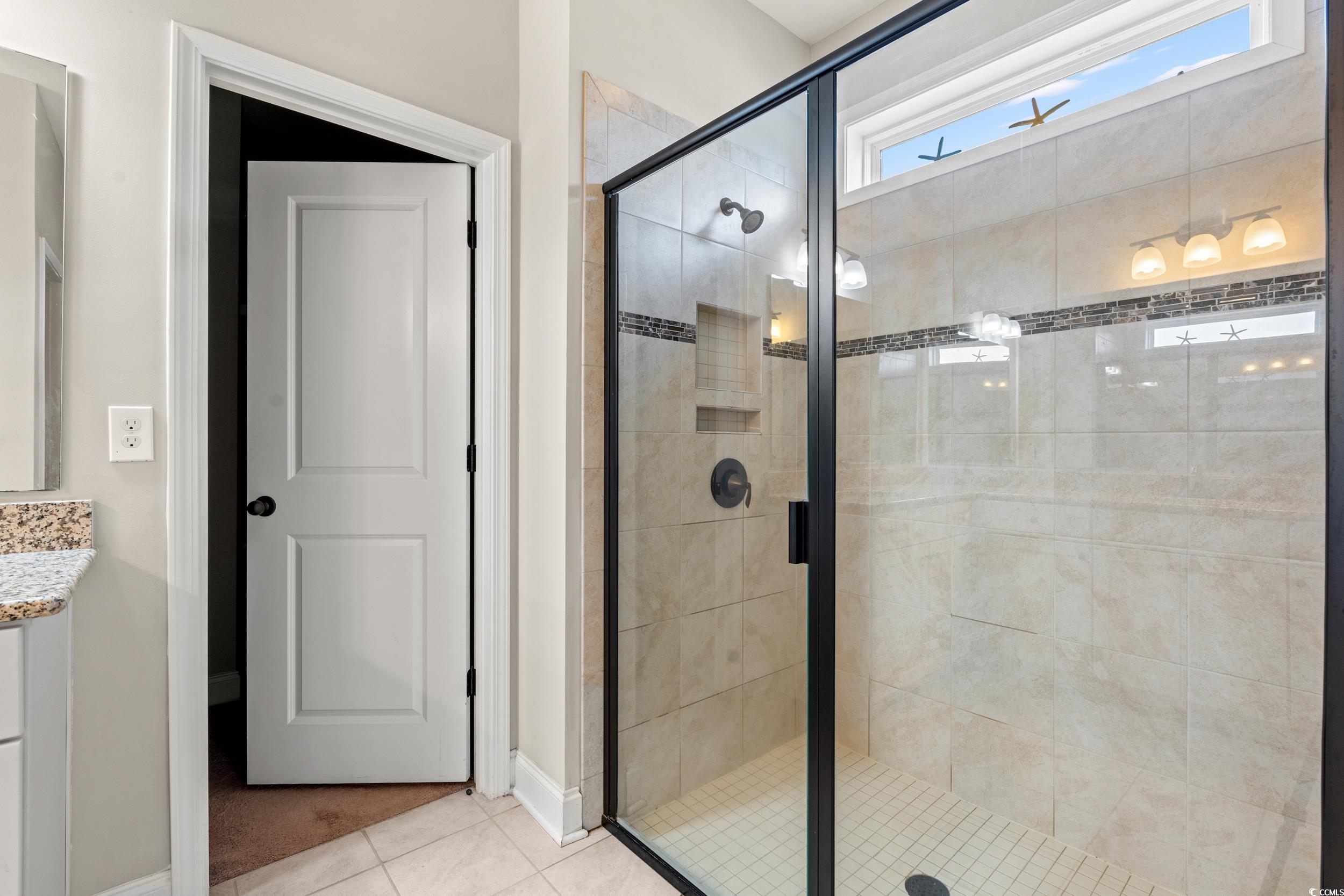 126 Viareggio Road Myrtle Beach, SC 29579 - Photo 16 of 40 Bathroom with vanity, a stall shower, and light tile patterned flooring