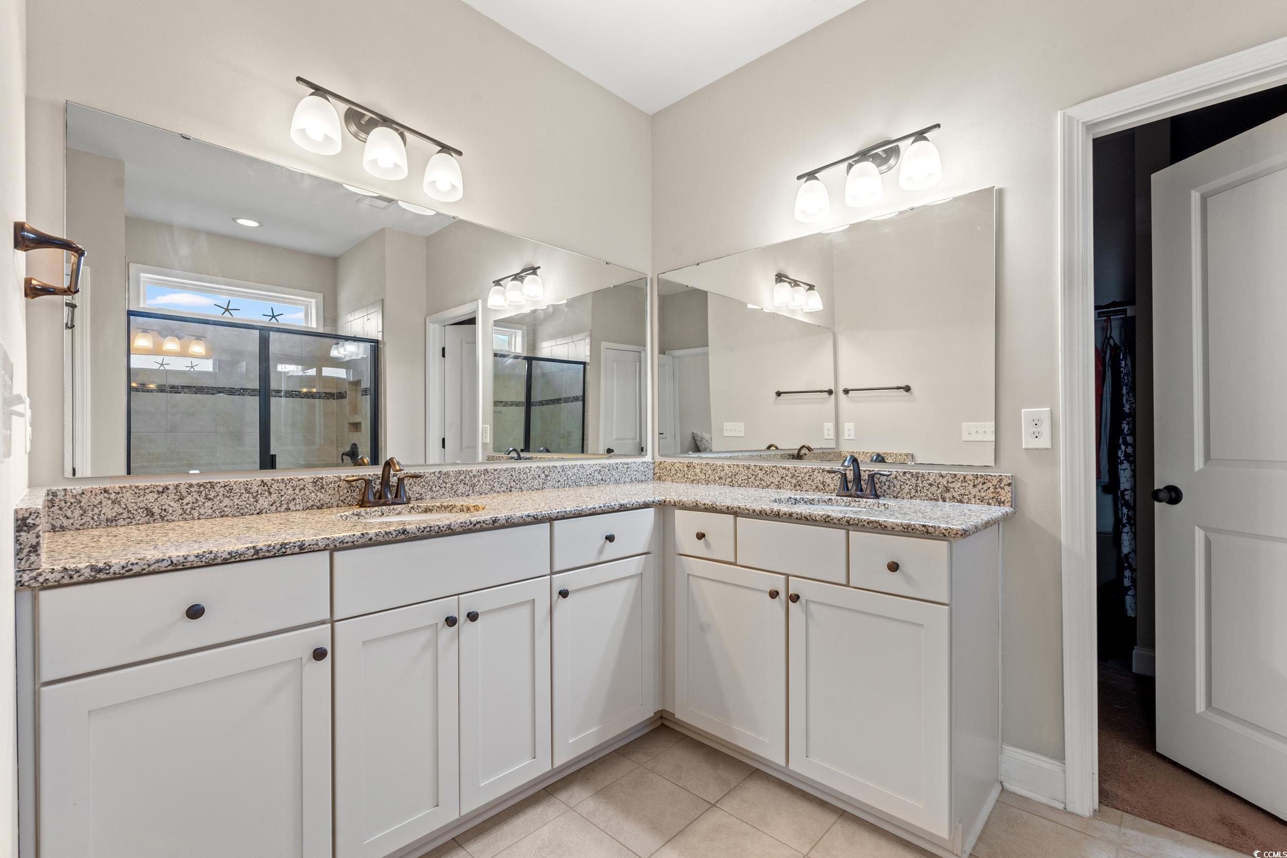 126 Viareggio Road Myrtle Beach, SC 29579 - Photo 21 of 40 Full bathroom featuring a shower stall, double vanity, a walk in closet, and light tile patterned flooring