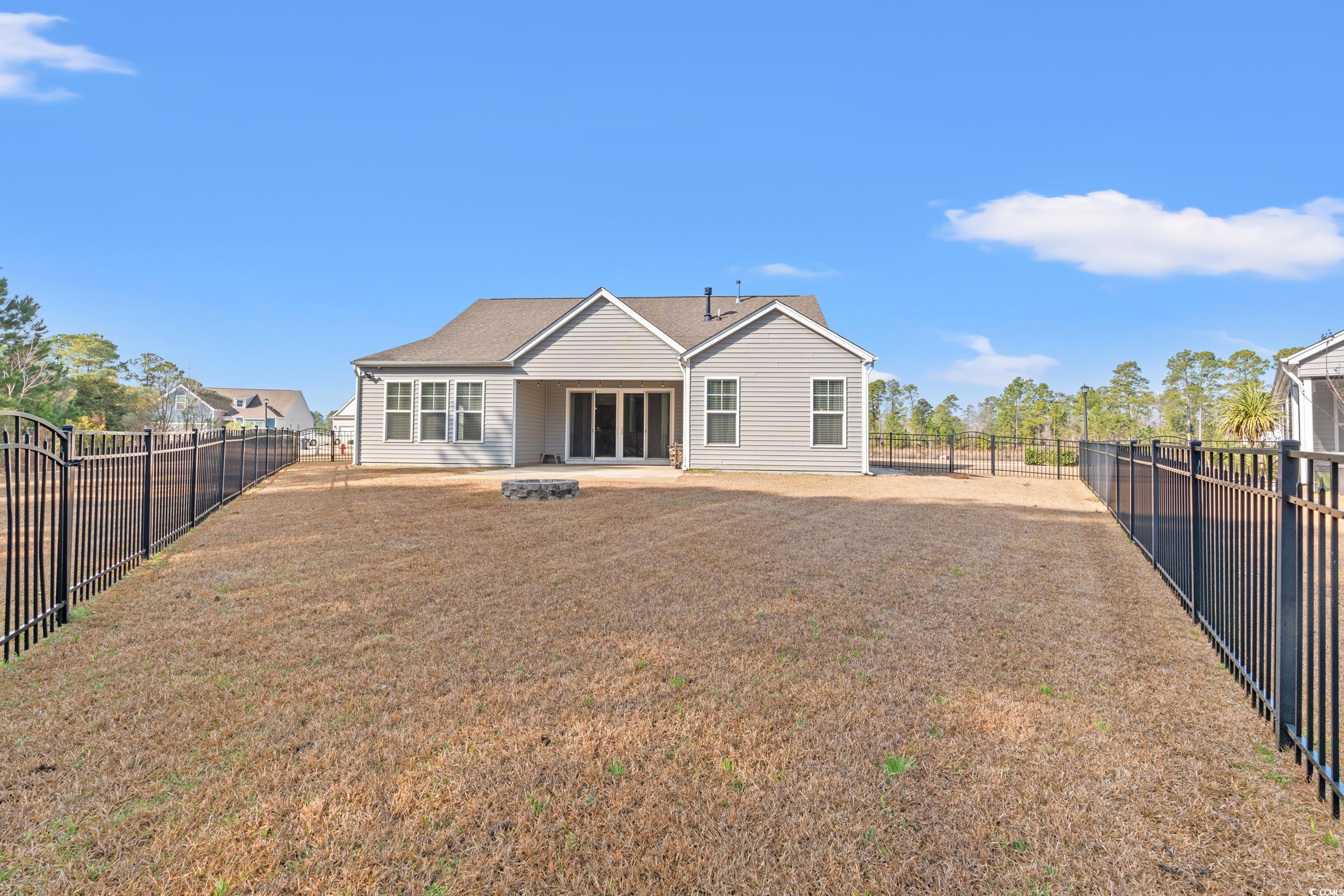 126 Viareggio Road Myrtle Beach, SC 29579 - Photo 29 of 40 Rear view of property featuring a patio area, a fenced backyard, and a fire pit