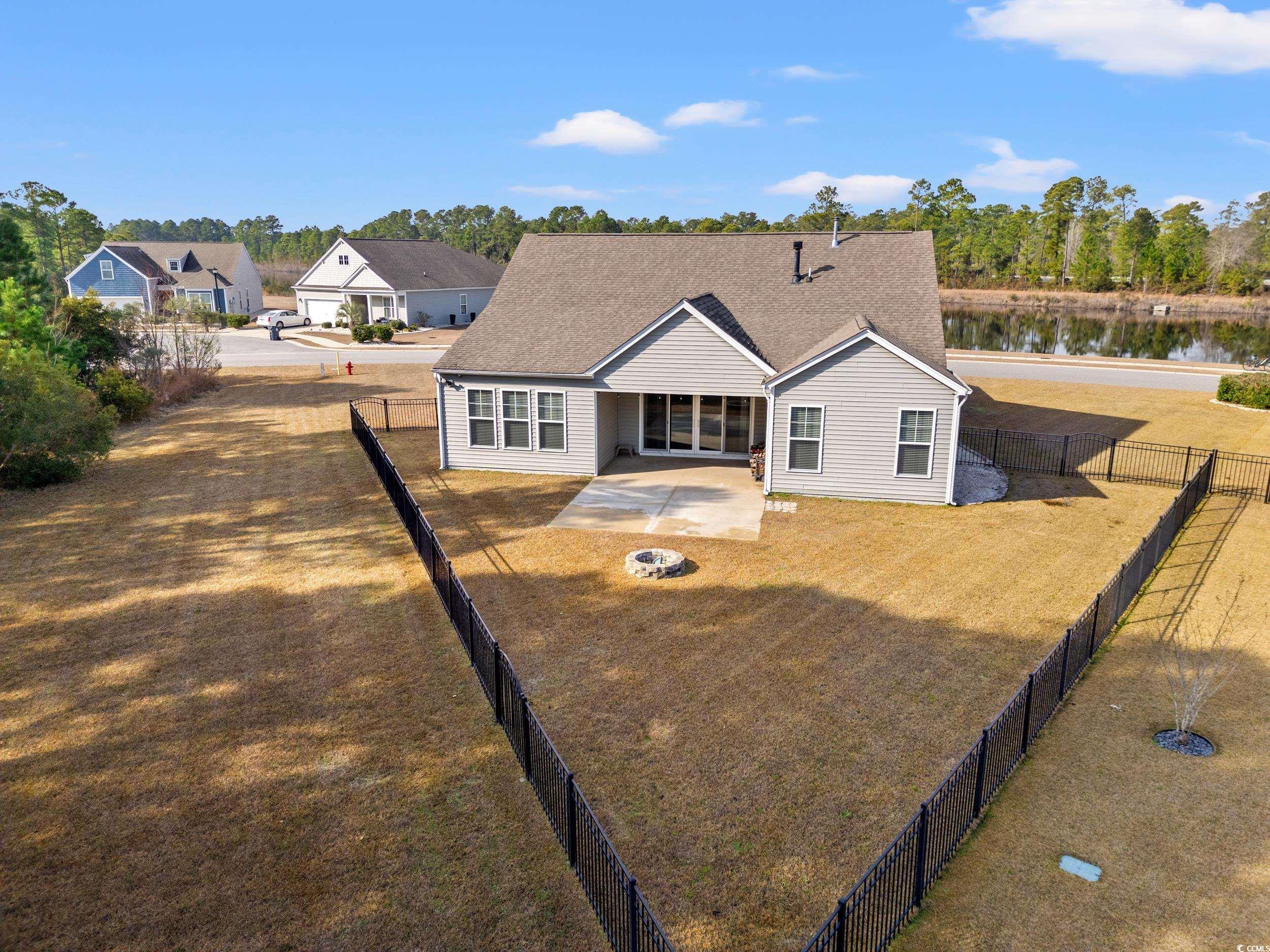 126 Viareggio Road Myrtle Beach, SC 29579 - Photo 31 of 40 Rear view of house featuring a patio, a fenced backyard, a shingled roof, and a fire pit