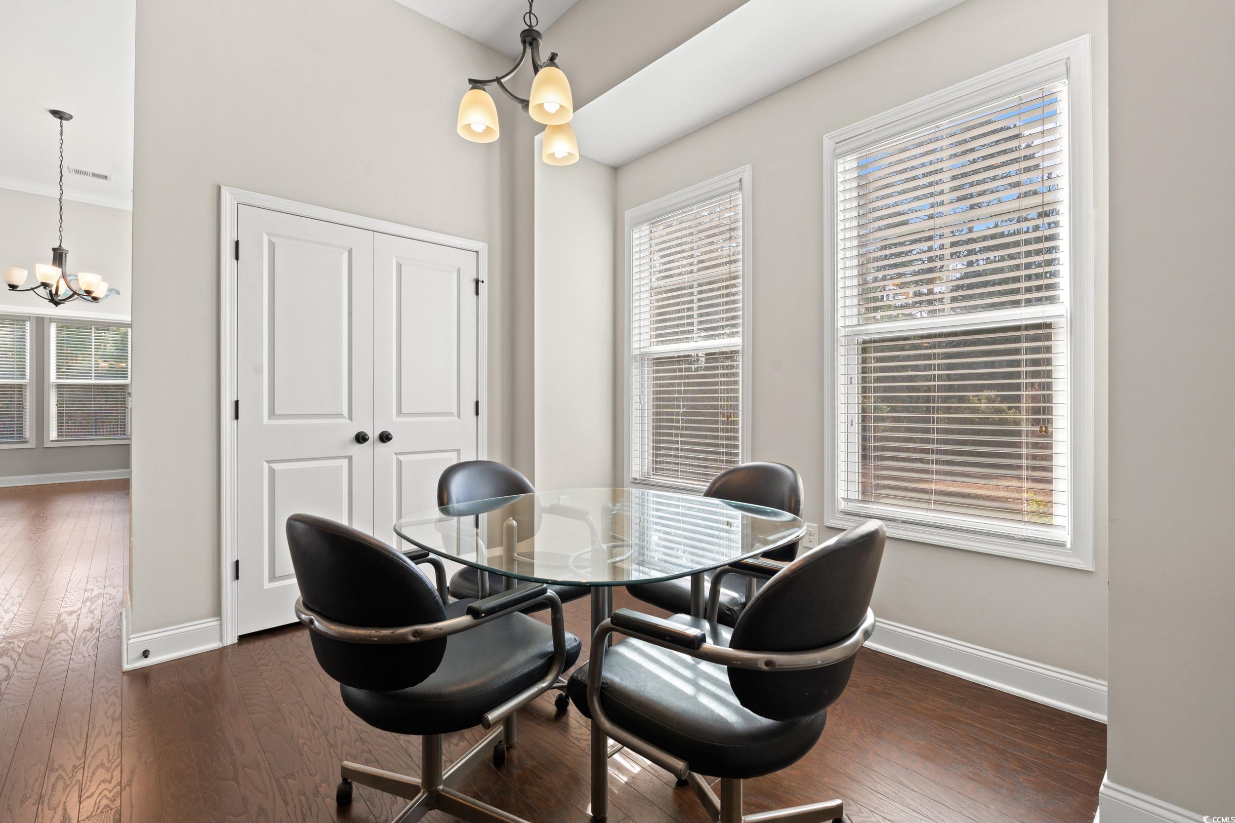 126 Viareggio Road Myrtle Beach, SC 29579 - Photo 6 of 40 Dining area with a chandelier, dark wood-style floors, and plenty of natural light