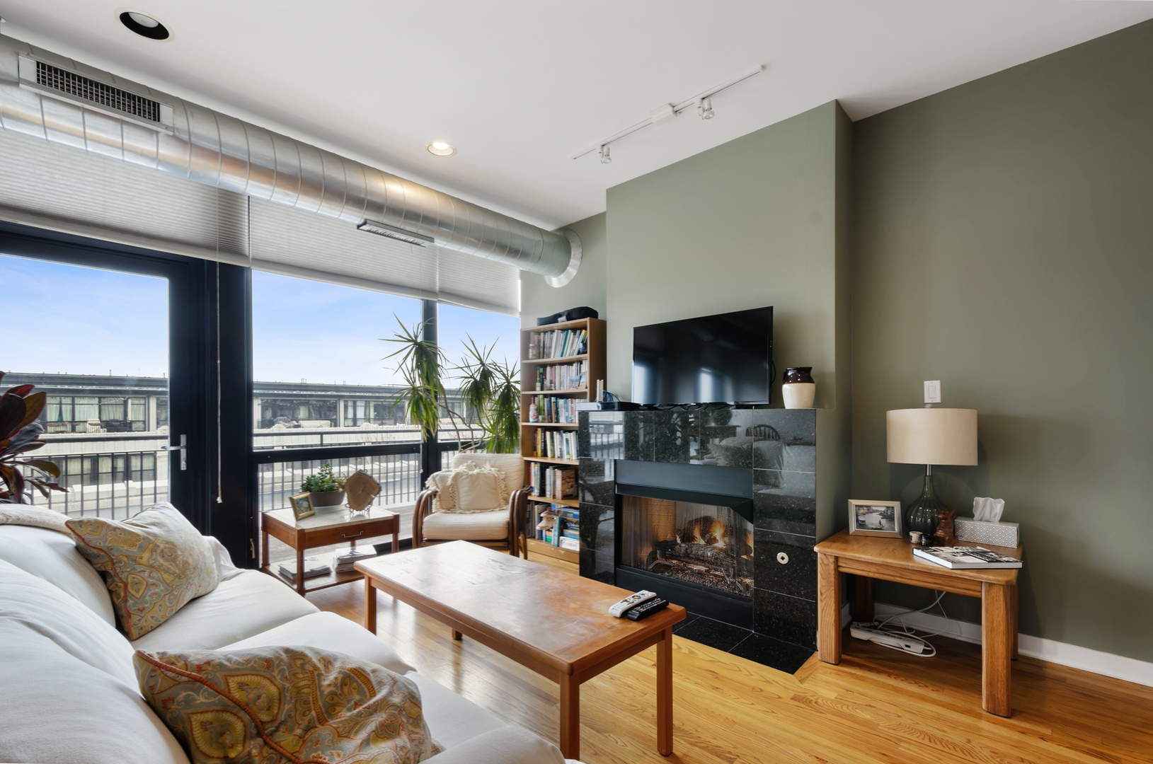 1110 West 15th Street, Unit 412 Chicago, IL 60608 - Photo 5 of 19 a living room with furniture a large window and a flat screen tv