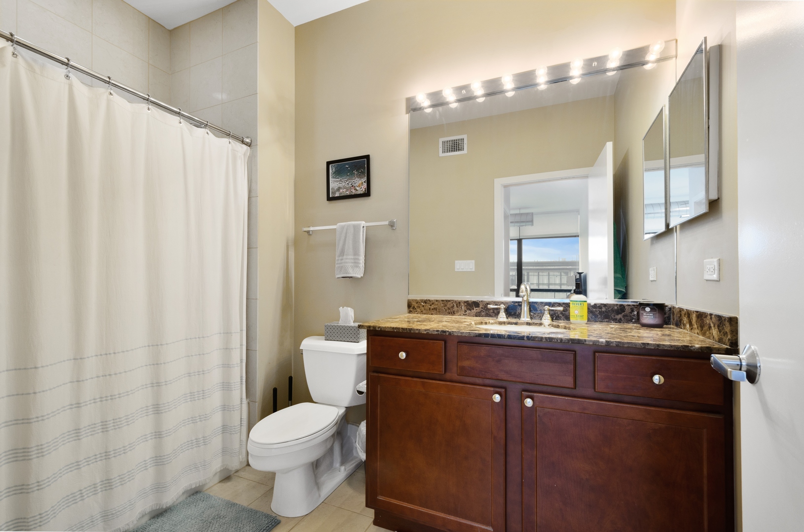 1110 West 15th Street, Unit 412 Chicago, IL 60608 - Photo 10 of 19 a bathroom with a granite countertop toilet sink and mirror