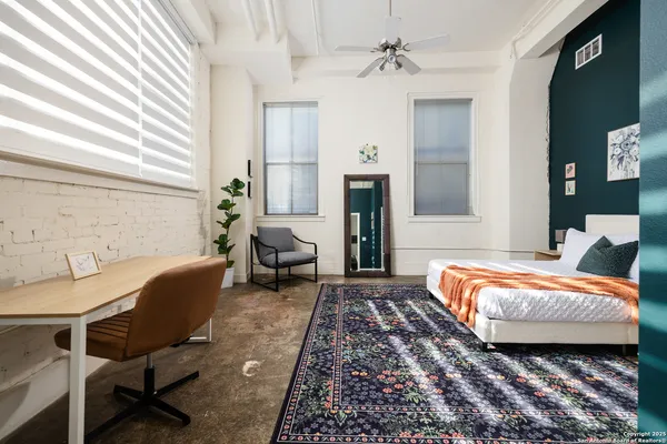 a bed sitting in a bedroom next to a lamp
