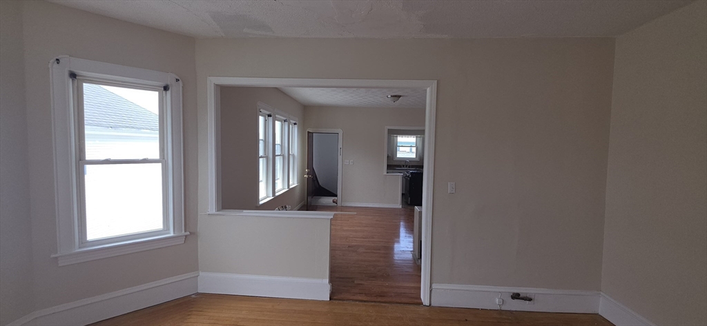 105 6th Street, Unit 3 Fall River, MA 02721 - Photo 3 of 10 an empty room with wooden floor and windows