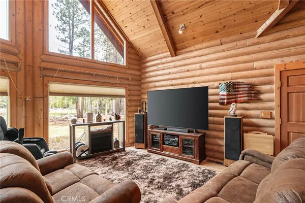 a living room with furniture a flat screen tv and a floor to ceiling window