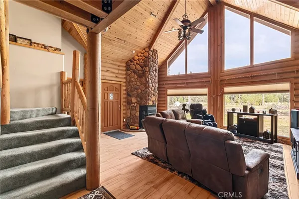 a living room with furniture a flat screen tv and a large window