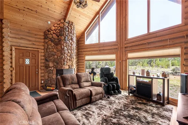 a living room with furniture a flat screen tv and a floor to ceiling window