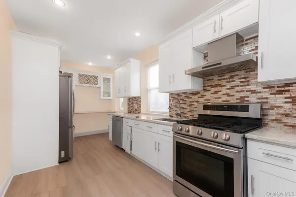a kitchen with white cabinets and appliances