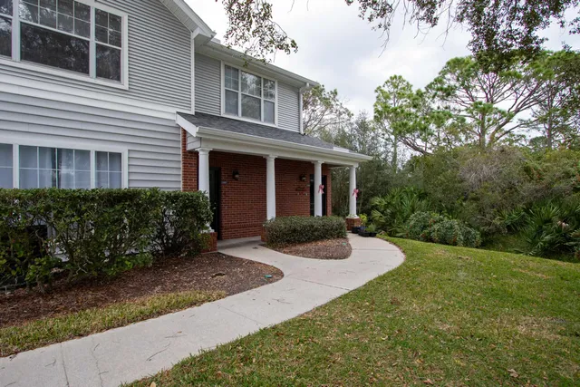 a front view of a house with yard and green space