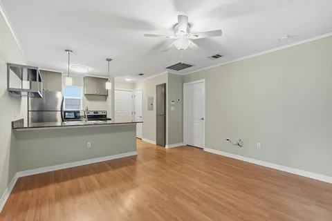 a kitchen with stainless steel appliances granite countertop a sink a stove and a wooden floors