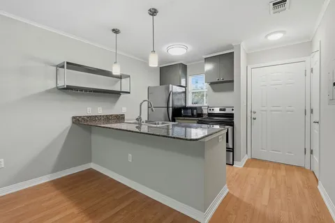 a kitchen with kitchen island a sink appliances and wooden floor