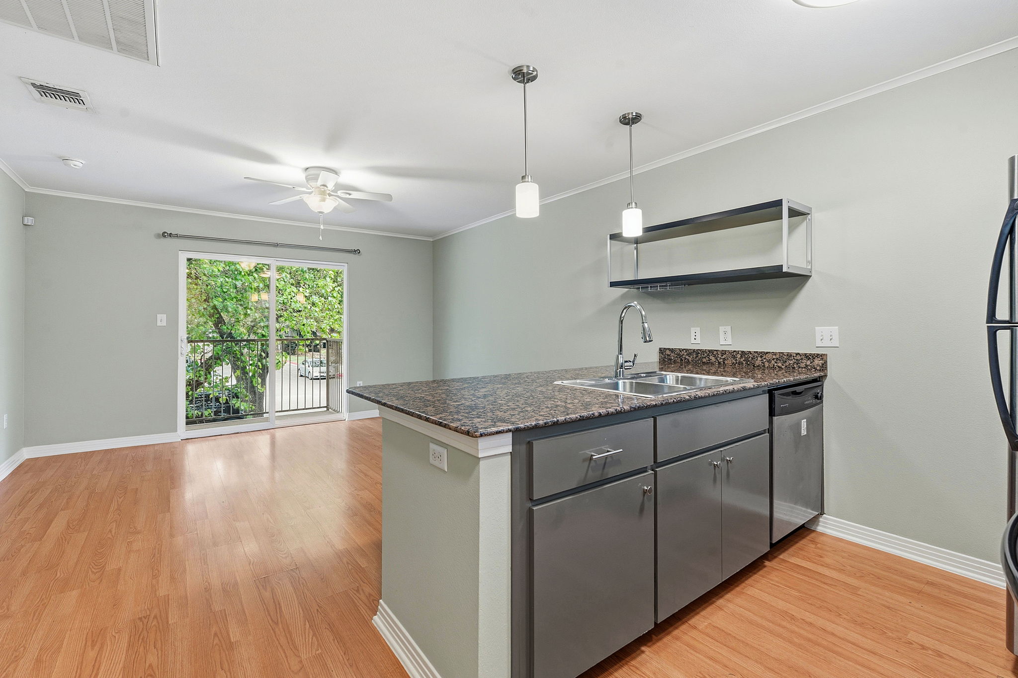 1422 Collier Street, Unit 203 Austin, TX 78704 - Photo 8 of 21 This property features a kitchen island with a double sink, granite countertops, and pendant lighting