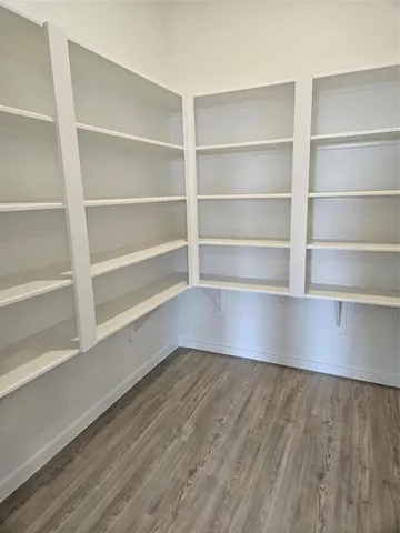 a view of a hallway with wooden shelves