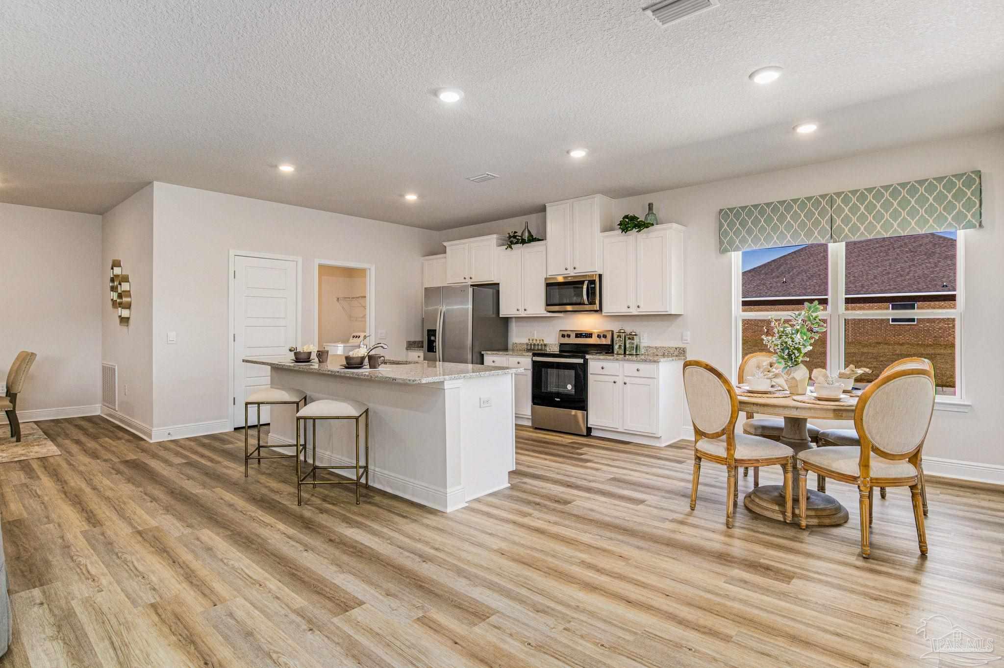 3821 Eagle Tail Drive Jay, FL 32565 - Photo 16 of 27 a living room with stainless steel appliances furniture and a wooden floor