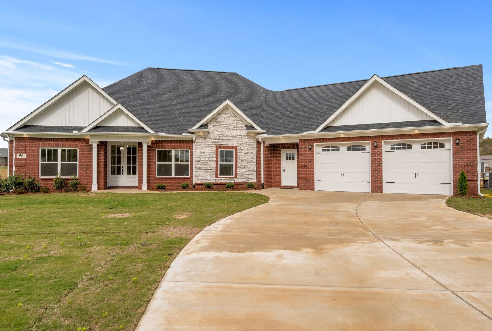 a front view of a house with a garden and yard