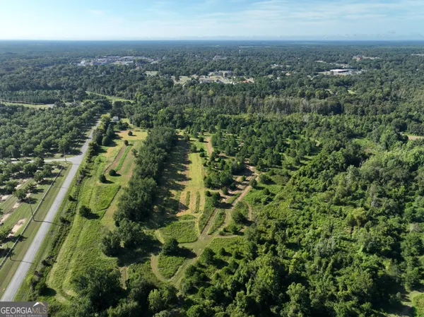 an aerial view of residential building with green space and fog