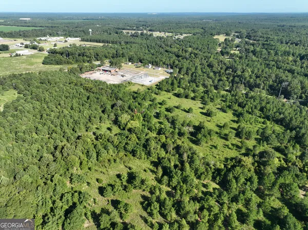 an aerial view of a houses with a yard and lake view