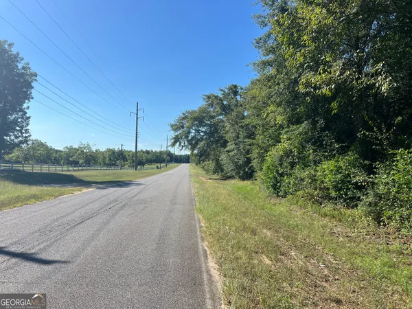 a view of a lake with a yard and large trees