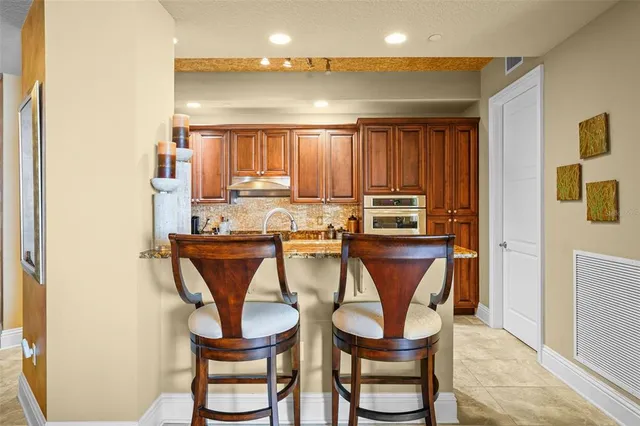 a kitchen with a dining table chairs and a refrigerator