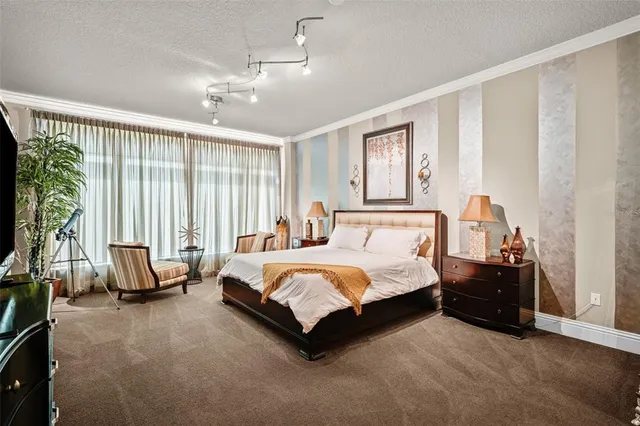 a spacious bedroom with a bed and large windows