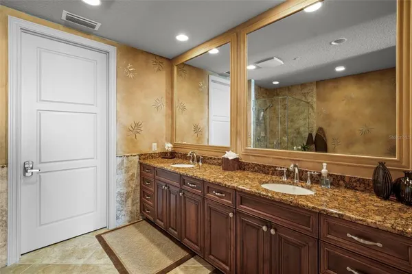 a bathroom with a granite countertop sink a mirror and a shower