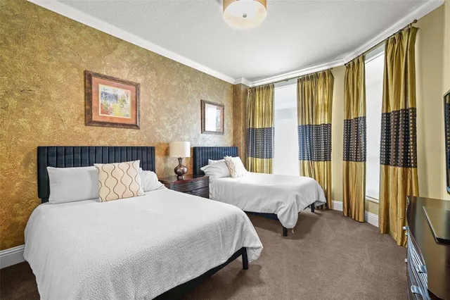 a bedroom with two beds and a large window