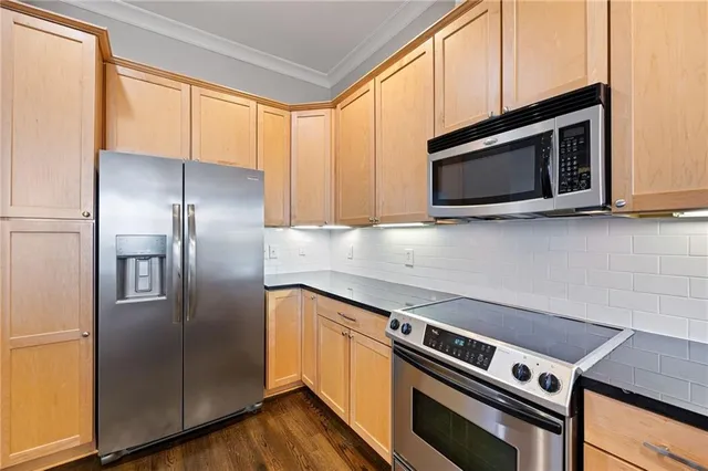 a kitchen with stainless steel appliances and wooden cabinets