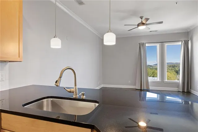 a kitchen with a sink a chandelier and living area view