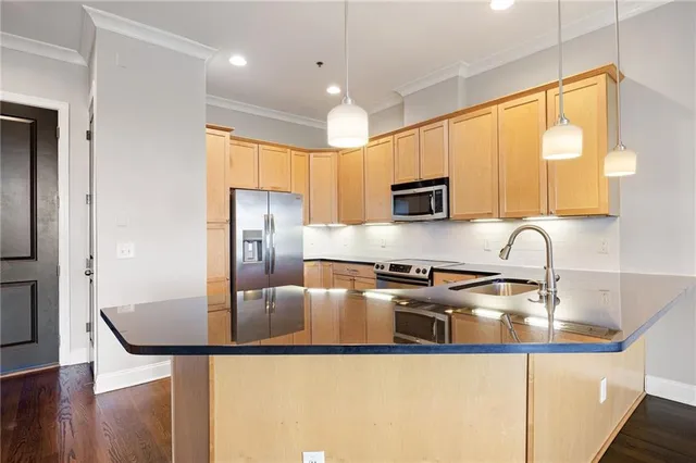 a kitchen with stainless steel appliances granite countertop a sink a stove and a refrigerator