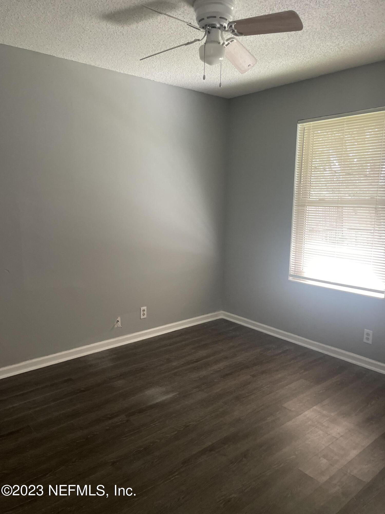 7952 Gulf Road South Jacksonville, FL 32244 - Photo 8 of 14 an empty room with wooden floor and windows