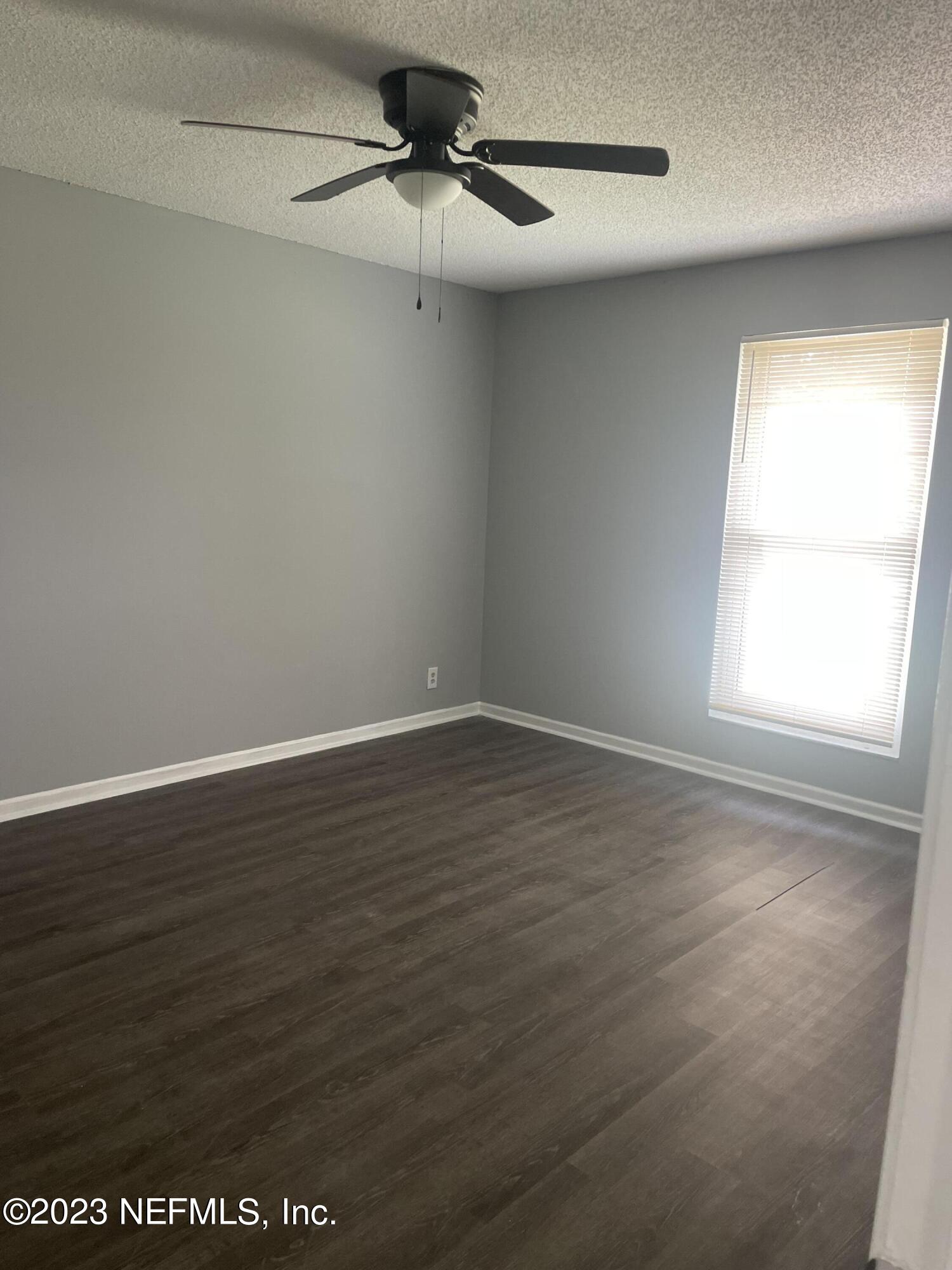 7952 Gulf Road South Jacksonville, FL 32244 - Photo 10 of 14 an empty room with wooden floor fan and windows