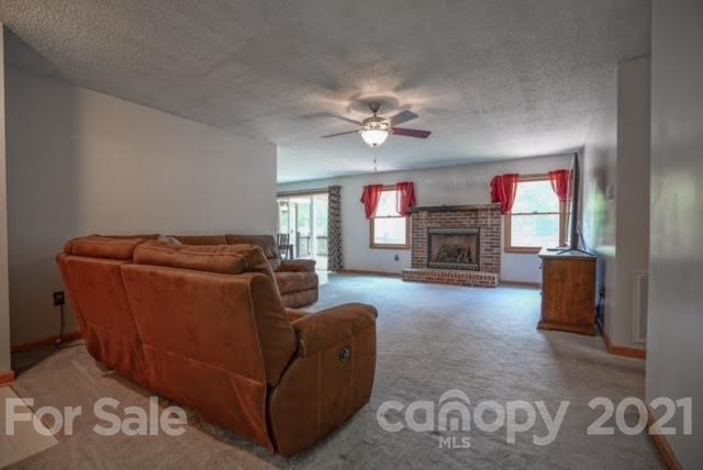 9675 Mt Olive Road Mount Pleasant, NC 28124 - Photo 11 of 48 a living room with furniture a fireplace and a flat screen tv